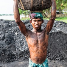 Man carrying basket full of coal on his head, Charkawa village, East Side of Kirtonkhola River, Barisal, Barisal District, Bangladesh, Indian Sub-Continent, Asia.